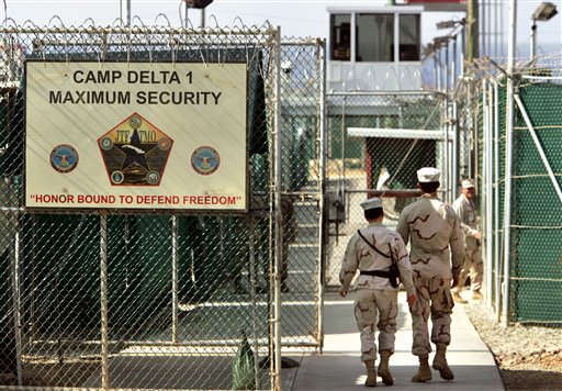 In this June 27, 2006 file photo, reviewed by a US Department of Defense official, U.S. military guards walk within Camp Delta military run prison, at the Guantanamo Bay U.S. Naval Base, Cuba. The classified diplomatic cables released by online whistle blower WikiLeaks and reported on by The New Tork Times cited documents showing the U.S. used hardline tactics to win approval from countries to accept freed detainees from Guantanamo Bay. (AP Photo/Brennan Linsley, File)