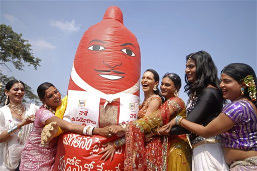 Indian transgenders stand with a giant condom during an awareness rally to mark World AIDS Day in Hyderabad, India, Wednesday, Dec. 1, 2010. (AP Photo/Mahesh Kumar A.)