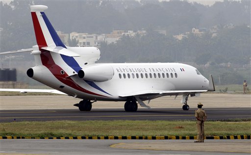 Indian security personnel stand guard as the aircraft of part of the French delegation lands in Bangalore, India, Saturday, Dec. 4, 2010. French President Nicolas Sarkozy and first lady Carla Bruni Sarkozy traveling in another plane landed in Bangalore, India, for a four day visit to India during which the two sides are expected to sign agreements to set up nuclear power plants in India and jointly develop satellites to study climate change. (AP Photo/Aijaz Rahi)