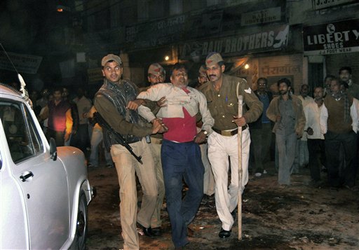 Indian policemen help an injured victim after an explosion in Varanasi, India, Tuesday, Dec. 7, 2010. A bomb hidden in a metal canister exploded Tuesday evening as thousands gathered for a Hindu ceremony, killing a toddler and triggering a stampede that left many others wounded in a holy Indian city. The bomb was stashed in a milk container on the Sheetla Ghat, one of many stone staircases leading to the Ganges river, the site of daily spiritual rituals, according to police official Brij Lal. (AP Photo)