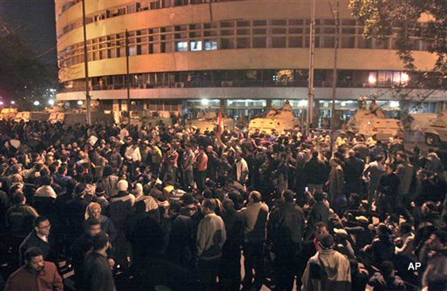 Anti government protesters surround the state television building following Egyptian President Hosni Mubarak's televised speech, on the Corniche in downtown Cairo, Egypt Thursday, Feb. 10, 2011. Mubarak refused to step down or leave the country and instead handed his powers to his vice president Thursday, remaining president and ensuring regime control over the reform process, which stunned protesters demanding his ouster, who waved their shoes in contempt and shouted, Leave, leave, leave. (AP Photo/Mohammed Abu Zaid)