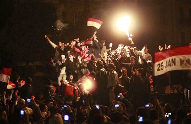 Protesters standing on a destroyed truck previously used as a barricade celebrate the resignation of Egyptian President Hosni Mubarak in Tahrir Square in downtown Cairo Friday, Feb. 11, 2011. Revelers swept joyously into the streets across the Middle East on Friday after Mubarak stepped down as Egypt's president. From Beirut to Gaza, tens of thousands handed out candy, set off fireworks and unleashed celebratory gunfire, and the governments of Jordan, Iraq and Sudan sent their blessings. (AP Photo/Ben Curtis)