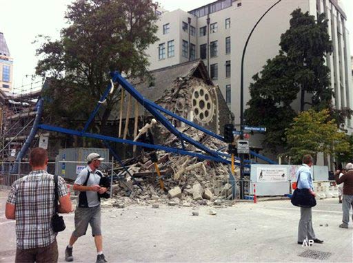 People look at a damaged church after a powerful earthquake struck Christchurch, New Zealand, Tuesday, Feb, 22, 2011. The 6.3 magnitude quake collapsed buildings and is sending rescuers scrambling to help trapped people amid reports of multiple deaths. (AP Photo/Layton Duncan)