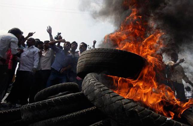 Protestors demanding the creation of a separate Telangana state, burn tyres to block traffic in Hyderabad, India, Wednesday, Feb. 23, 2011. (AP Photo/Mahesh Kumar A.)