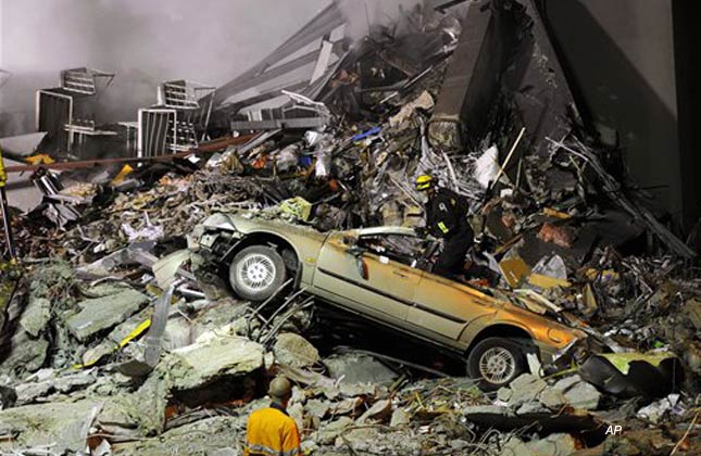 Rescue workers search for victims buried under the rubble near the Canterbury Television building in Christchurch, New Zealand, Wednesday night, Feb. 23, 2011. Students from across Asia are feared among the dead in the CTV building that collapsed in Tuesday's earthquake, with police saying Wednesday that they were 100 percent certain no one trapped in the rubble was alive. (AP Photo/Kyodo News, Shuzo Shikano)