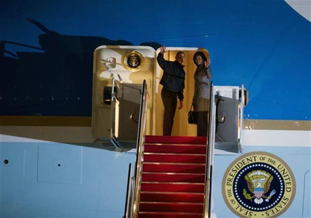 President Barack Obama and first lady Michelle Obama wave from Air Force One before departure, at Andrews Air Force Base, Md., Saturday, Jan. 24, 2015, for a trip to New Delhi, India, by way of Ramstein Air Base, Germany.