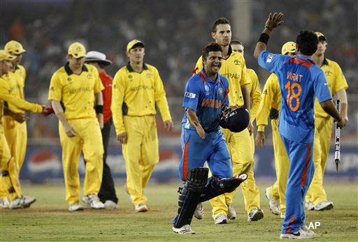 India's Suresh Raina, holding helmet in his hand, celebrates their win with fellow team member Virat Kohli, right, back to camera, in the Cricket World Cup quarterfinal match between India and Australia, in Ahmedabad, India, Thursday, March 24, 2011. (AP Photo/Aijaz Rahi)