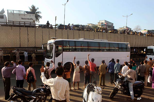 Supporters and onlookers line the road to wave and cheer at a bus transporting India's cricket team, after their arrival from Mohali at the airport in Mumbai, India, Thursday, March 31, 2011. India will face Sri Lanka in the final of the Cricket World Cup in Mumbai on Saturday, April 2. (AP Photo/Rafiq Maqbool)