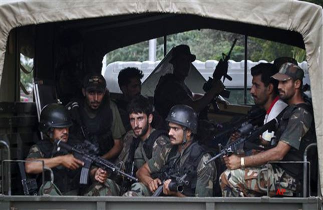 Pakistani army commandos drive through the main gate of a naval aviation base following an attack by militants in Karachi, Pakistan, Monday, May 23, 2011. Militants attacked the base in the southern Pakistani city of Karachi late Sunday, rocking the base with explosions and battling commandos sent in to subdue the attackers, security officials said. (AP Photo/Shakil Adil)