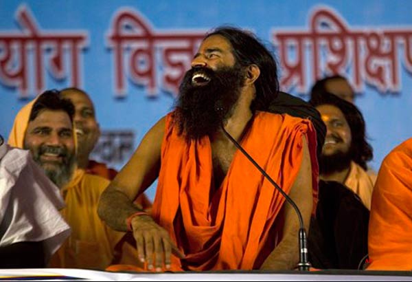 Renowned yoga guru Baba Ramdev gestures during his hunger strike against corruption in New Delhi, India, Saturday, June 4, 2011. The charismatic and controversial yoga guru Baba Ramdev is spinning that popularity to fuel a political movement that he says will root out India's endemic corruption. The saffron robed and bearded Ramdev started an indefinite hunger strike in the Indian capital Saturday that his critics say undermines the country's democratic institutions, but that he says will last until the government agrees one hundred percent to his long list of demands. (AP Photo/Manish Swarup)