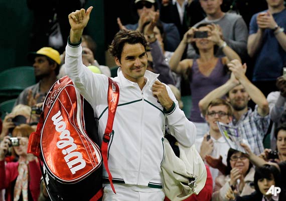 Switzerland's Roger Federer waves to the crowd after winning his second round match against France's Adrian Mannarino at the All England Lawn Tennis Championships at Wimbledon, Thursday, June 23, 2011. (AP Photo/Anja Niedringhaus)