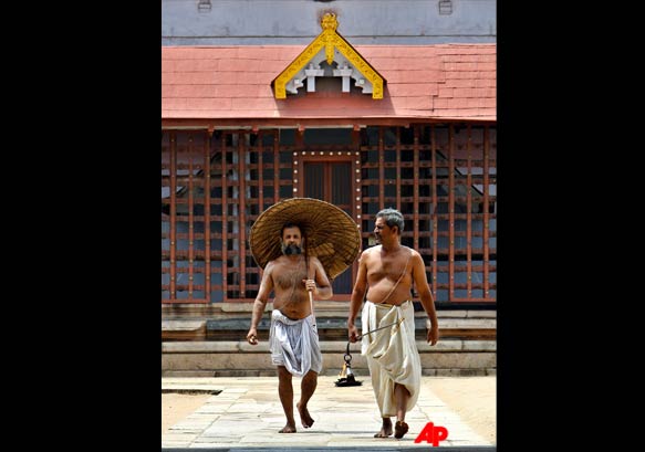 Hindu priests walk in front of a building housing the vaults at the 16th century Sree Padmanabhaswamy Temple complex in Trivandrum, India.
