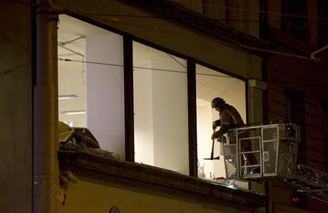 An emergency worker clears broken glass from a damaged window near the site of Friday's explosion in central Oslo, Norway, in the early hours of Saturday, July 23, 2011. A homegrown terrorist set off the explosion that ripped open buildings in the heart of Norway's government, then went to a summer camp dressed as a police officer and gunned down youths as they ran and even swam for their lives, police said Friday. (AP Photo/Matt Dunham)