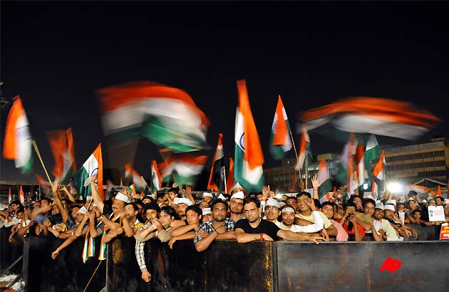 Supporters wave Indian flags at the ground where Indian rights activist Anna Hazare is on his sixth day of hunger strike in New Delhi, India, Sunday, Aug. 21, 2011.Hazare, who is on a hunger strike to demand that Indian lawmakers pass his anti corruption bill said Sunday that his supporters comprise a people's parliament above the nation's elected assembly.Hazare's campaign has received nonstop media attention and widespread support among both wealthy and poor Indians fed up with rampant bribery and favoritism.