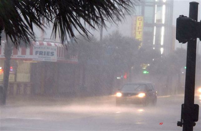 A downpour from Hurricane Irene slows traffic in downtown Myrtle Beach, S.C., on Friday, Aug. 26, 2011. Irene has the potential to cause billions of dollars in damage all along a densely populated arc that includes Washington, Baltimore, Philadelphia, New York, Boston and beyond. At least 65 million people could be affected. (AP Photo/Bruce Smith)