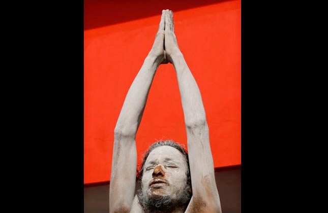 A Naga sadhu, or naked Hindu holy man, performs rituals on the banks of the River Ganges during the Kumbh Mela in Haridwar, India, Saturday, March 13, 2010. Devout Hindus bathe in the Ganges during the months long festival, expected to attract more than 10 million people, with the belief that it will cleanse them of their sins and free them from the cycle of life and rebirth. (AP Photo/Rajesh Kumar Singh)