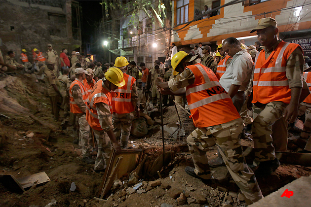 Rescue workers remove the debris as they look for survivors after a building collapsed in New Delhi, India, Wednesday, Sept. 28, 2011. At least eight people were killed and 25 others injured when the old three story building collapsed near Jama Masjid area, according to a news agency. At least five people are still feared trapped under the debris, police said. (AP Photo/Altaf Qadri)