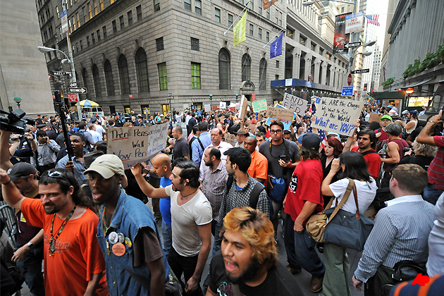 Protestors march up Wall Street towards the New York Stock Exchange in Manhattan, Monday, Sept. 26, 2011, in New York. The Occupy Wall Street protest is in its second week, as demonstrators speak out against corporate greed and social inequality. (AP Photo/Louis Lanzano)