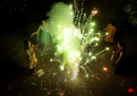 In this Wednesday Oct. 26, 2011, photograph, Indian women burn fire crackers during the Diwali festival, the Hindu festival of lights, in Hyderabad, India.(AP Photo/ Mahesh Kumar)