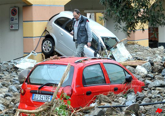 Car wrecks lay in the debris, in the small town of Monterosso in the Italian north western region of Liguria, Thursday, Oct. 27, 2011, following violent rains and floods that struck in the area. Soldiers and civilian rescue workers battled knee deep mud Thursday as they searched for survivors after flash floods and mudslides inundated picturesque villages around coastal areas of Liguria and Tuscany. (AP Photo/Massimo Pinca)