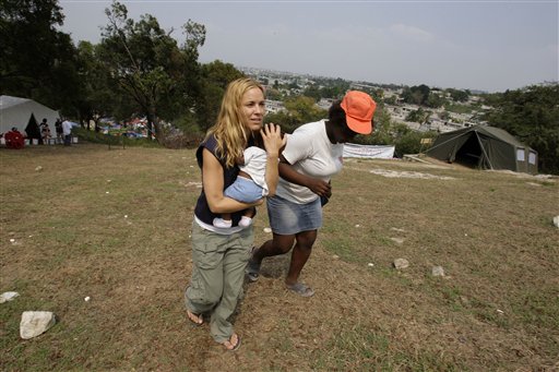 US actress Maria Bello holds baby Blondina Pierre as she walks with Blondina's mother, Daniella Pierre, to the field hospital at the makeshift camp for earthquake survivors set up in the Petionville Golf Club in Port au Prince, Sunday, March 14, 2010. Bello is doing aid work through the Jenkins Penn Haiti Relief Operation, in the aftermath of Jan. 12 earthquake. (AP Photo/Andres Leighton)