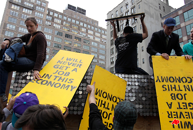 Occupy Wall Street protesters move signs and structures over a wall into an enclosed site near Canal Street in New York, Tuesday, Nov. 15, 2011. Protesters vowed to regroup after an early morning police raid removed their encampment from Zuccotti Park. Hundreds of police officers in riot gear before dawn Tuesday raided the New York City park where the Occupy Wall Street protests began, evicting and arresting hundreds of protesters from what has become the epicenter of the worldwide movement protesting corporate greed and economic inequality. (AP Photo/Seth Wenig)