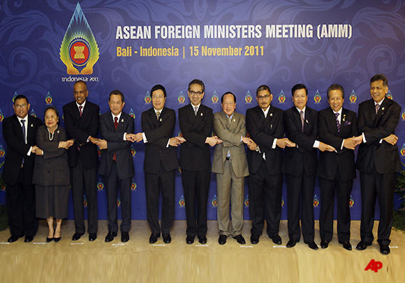 ASEAN foreign ministers and their representatives hold hands during a group photo session of the ASEAN Foreign Ministers Meeting at Bali, Indonesia on Tuesday Nov. 15, 2011. From left are Myanmar's Foreign Minister Wunna Maung Lwin, Philippines undersecretary for Foreign Affairs Erlinda Basilio, Singapore's Foreign Minister K. Shanmugam, Thailand's Vice Minister for Foreign Affairs Jullapong Nonsrichai, Vietnam Foreign Minister Pham Binh Minh, Indonesian Foreign Minister Marty Natalegawa, Cambodian Foreign Minister Hor Namhong, Brunei's Acting Minister for Foreign Affairs Erywan Dato Pehin, Laos Foreign Minister Thongloun Sisoulith, Malaysian Foreign Minister Anifah Aman and ASEAN Secretary General Surin Pitsuwan. (AP Photo/Aaron Favila)