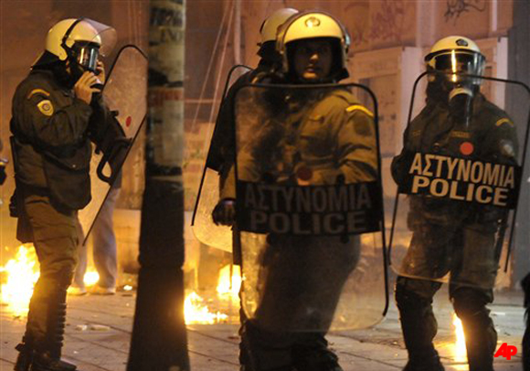 Riot police try to avoid petrol bombs thrown by youths during clashes at the northern port city of Thessaloniki, Greece, Tuesday evening Dec. 6, 2011. Protesting high school students hurled rocks and bottles during clashes with police Tuesday during a rally to mark the third anniversary of the fatal police shooting of a teenager in central Athens. (AP Photo/Nikolas Giakoumidis)