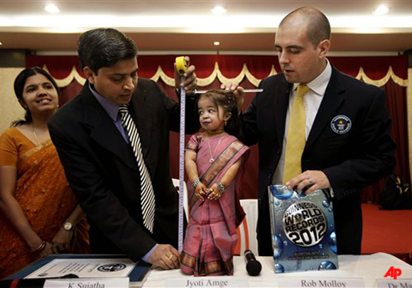 Guinness World Records adjudicator Rob Molloy, right, and Dr. Manoj Pahukar of Wockhardt hospital, second left, measure Jyoti Amge at a press conference in Nagpur, India, Friday, Dec. 16, 2011. Amge, 18, was declared shortest woman in the world measuring 62.8 centimeters (24.7 inches) by the Guinness World Records. (AP Photo/Manish Swarup)