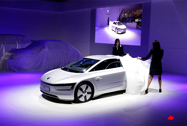 Indian models unveil Volkswagen's concept car XL1 during a press preview at the India Auto Expo, in New Delhi, India, Thursday, Jan. 5, 2012. The five day long automobile event begins Saturday. (AP Photo/ Manish Swarup)