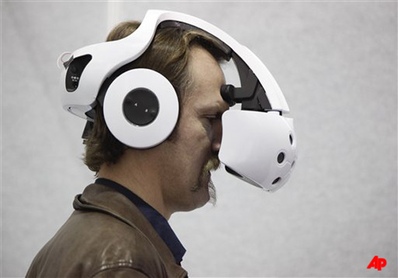 An industry affiliate tries out the Sensics 3D SmartGoggles headset at the 2012 International Consumer Electronics Show, Thursday, Jan. 12, 2012, in Las Vegas. (AP Photo/Julie Jacobson)