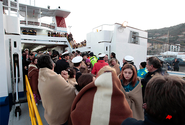 Passengers of the luxury ship Costa Concordia that ran aground off the coast of Tuscany disembark a ferry in Porto Santo Stefano, Italy, Saturday, Jan. 14, 2012. The Costa Concordia ran aground, gashing open the hull and taking on water, forcing some 4,200 people aboard to evacuate aboard lifeboats to a nearby island early Saturday. (AP Photo/Gregorio Borgia)