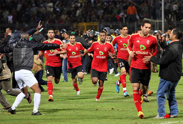 Team players of the Egyptian Al Ahly club run for safety during clashes following their soccer match against Al Masry club at the soccer stadium in Port Said, Egypt Wednesday, Feb. 1, 2012. Dozens of Egyptians were killed Wednesday in violence following a soccer match in Port Said, when fans flooded the field seconds after a match against a rival team was over, Egypt's Health ministry said. (AP Photo/Ahmed Hassan)