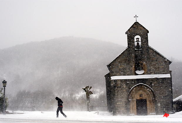 A man walks as snow and frozen wind billows cross the region, in Roncesvalles, northern Spain, Thursday Feb. 2, 2012. A cold spell has reached Europe with temperatures plummeting far below zero. (AP Photo/ Alvaro Barrientos)