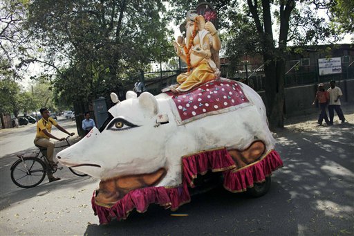 An auto rickshaw made to look like a large rat carries a statue of Hindu god Ganesh on top as it is driven during a small parade to mark a festival celebrating the birthday of Hindu god Rama in New Delhi, India, Wednesday, March 24, 2010. According to Hindu mythology, the rat is the vehicle of Lord Ganesh. (AP Photo/Kevin Frayer)