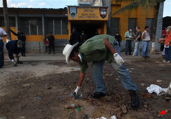 Leonardo Aguilar, an inmate who survived a deadly fire, cleans up inside the prison perimeter in Comayagua, Honduras, Honduras, early Thursday Feb. 16, 2012. A fire started by an inmate tore through the prison Tuesday night. Officials confirmed 358 dead, making it the world's deadliest prison fire in a century. (AP Photo/Esteban Felix)