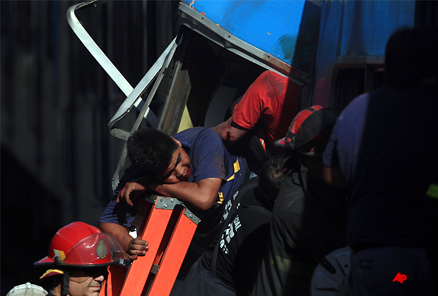 A wounded passenger waits to be rescued from a commuter train after a collision in Buenos Aires, Argentina, Wednesday Feb. 22, 2012. A packed train slammed into the end of the line in Buenos Aires' busy Once station Wednesday, killing dozens and injuring hundreds, according to police.