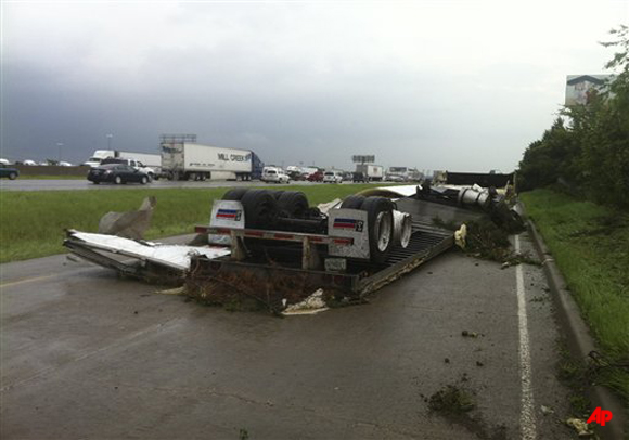 A trailer is over turned on I 20 near Bonny view in southern Dallas on Tuesday, April 3, 2012. Tornadoes tore through the Dallas area on Tuesday, tearing roofs off homes, tossing trucks into the air and leaving flattened tractor trailers strewn along highways and parking lots. The National Weather Service confirmed at least two separate large and extremely dangerous tornadoes in the Dallas Fort Worth area. Several other developing twisters were reported as a band of violent storms moved north through the metropolitan area. (AP Photo/The Dallas Morning News, Nathan Gerry McCarthy)