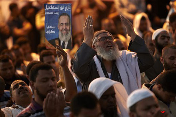 Followers of Egyptian Muslim cleric and former candidate for the Egyptian presidency Hazem Abu Ismail perform their evening prayer as they continue the protest at Tahrir Square, Cairo, Egypt Saturday, April. 21, 2012. The day after that tens of thousands of protesters packed Cairo's downtown Tahrir Square in the biggest demonstration in months against the ruling military, aimed at stepping up pressure on the generals to hand over power to civilians and bar ex regime members from running in upcoming presidential elections. (AP Photo/Fredrik Persson)