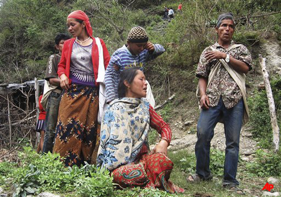 Nepalese people cry after their home was swept away by the rising waters of the River Seti in Yamdi village of Kaski district, about 200 kilometers (120 miles) west of capital Katmandu, Nepal, Saturday, May 5, 2012. A flooded mountain river has swept away dozens of people along with their houses, farms and cattle Saturday in western Nepal, officials said. Police official Shailesh Thapa said more than 10 bodies have been pulled out from the Seti river in Kaski district. (AP Photo/ Santosh Pokhrel)