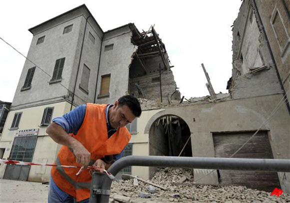 A volunteer ropes off the area surrounding a collapsed building in Finale Emilia, northern Italy after a quake hit northern Italy early Sunday, May 20, 2012. One of the strongest earthquakes to shake northern Italy rattled the region around Bologna early Sunday, a magnitude 6.0 temblor that killed at least four people, toppled buildings and sent residents running into the streets, emergency services and news reports said. (AP Photo/Marco Vasini)