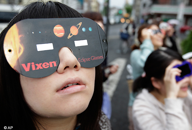 People watch the annular solar eclipse in Fujisawa, near Tokyo, Monday, May 21, 2012. Millions of Asians watched as a rare ring of fire eclipse crossed their skies early Monday. The annular eclipse, in which the moon passes in front of the sun leaving only a golden ring around its edges, was visible to wide areas across the continent.