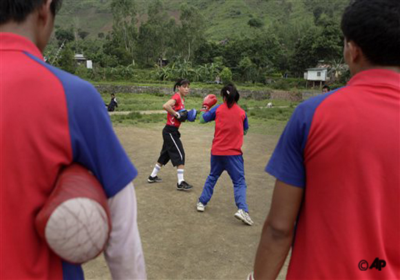 Indian boxer and five time world champion Mary Kom, center left, practices boxing with her student in Langol Games village on the outskirts of Imphal, India. Mother of two Mary Kom, otherwise known here as Magnificent Mary, is under all kinds of pressure while aiming, as she is, at winning one of the first Olympic medals ever awarded in women's boxing. (AP Photo/Anupam Nath)