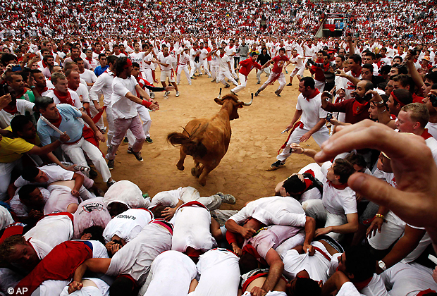 A cow jumps over revelers in a bullring during the second running of the bulls at the San Fermin fiestas, in Pamplona northern Spain, Sunday, July 8, 2012.(AP Photo/Ivan Aguinaga)