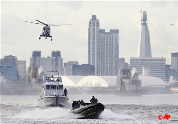 In this file photo security forces take part during in a combined British police and British Royal Marines security exercise for the London 2012 Olympic Games on the River Thames in London. Fighter jets thunder above the English countryside. Missiles stand ready.(AP Photo/Alastair Grant, File)