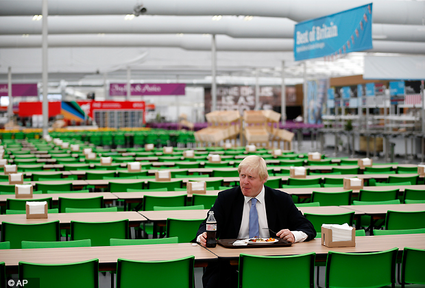 The mayor of London Boris Johnson poses for the media with a plate of food in the athletes' dining hall during a media opportunity at the Olympic and Paralympic athlete's village in London, Thursday, July 12, 2012. The London Olympics begin on July 27. (AP Photo/Matt Dunham)