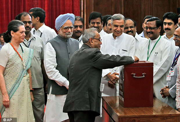 Candidate of India's ruling alliance, Pranab Mukherjee, casts his vote during India's presidential election as Prime Minister Manmohan Singh, third from left, and Congress party president Sonia Gandhi, left, along with other lawmakers look on in New Delhi, India, Thursday, July 19, 2012. (AP Photo)