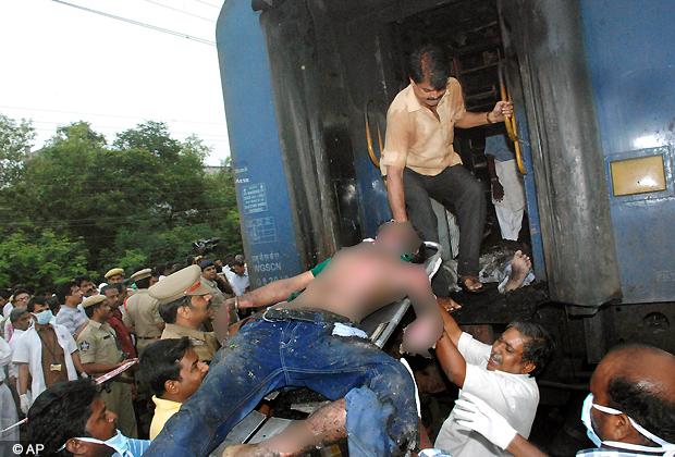 Railway officials take out a body of a passenger from a burnt coach of TN Express, at Nellor nearly 500 kilometers (310 miles) south of Hyderabad, July 30, 2012. A fire swept through a train car packed with sleeping passengers in southern India on Monday, killing at least 47 people. (AP Photo)