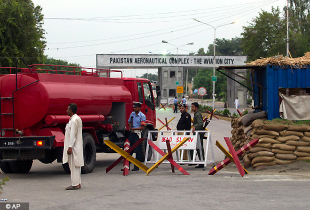 Pakistani security personnel guard the main entrance of Pakistan air force base in Kamra, about 85 kilometers northwest of Islamabad, Pakistan on Thursday, Aug. 16, 2012. Militants attacked the air force base filled with F 16s and other aircraft before dawn Thursday, sparking a heavy battle with security forces that left parts of the base in flames, officials said. (AP Photo)