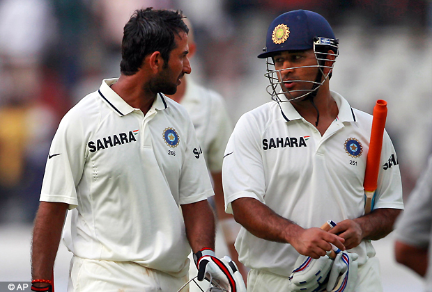 Indian batsmen Cheteshwar Pujara, left, and Mahendra Singh Dhoni leave the ground at the end of the first day of the first cricket test match against New Zealand in Hyderabad, India, Thursday, Aug. 23, 2012. (AP Photo)